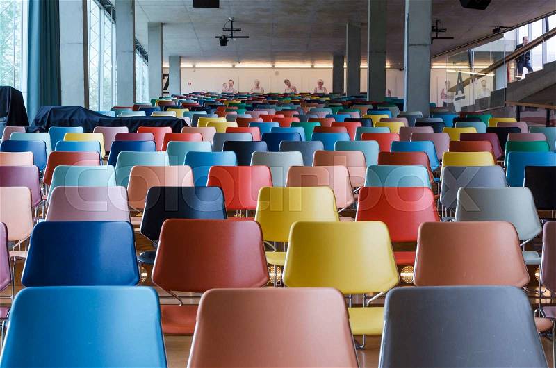Rows of colorful chairs in modern auditorium, stock photo