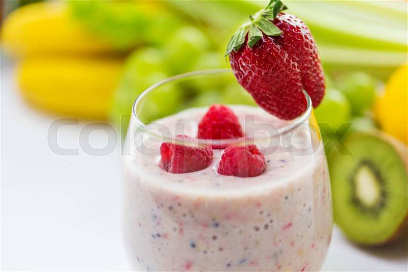 Healthy eating, cooking, vegetarian food, dieting and people concept - close up of glass with strawberry milk shake and fruits, stock photo