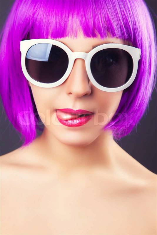 Beautiful woman wearing colorful wig against gray background, stock photo