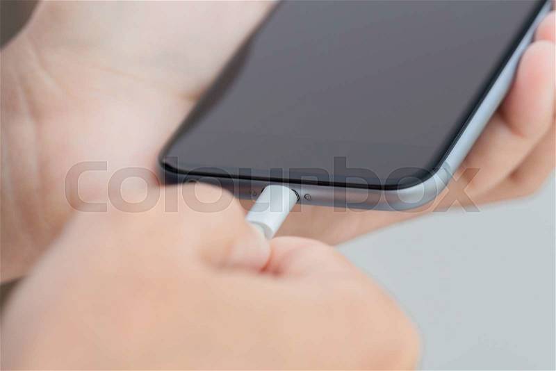 Close up hand using usb cable connect to phone, stock photo