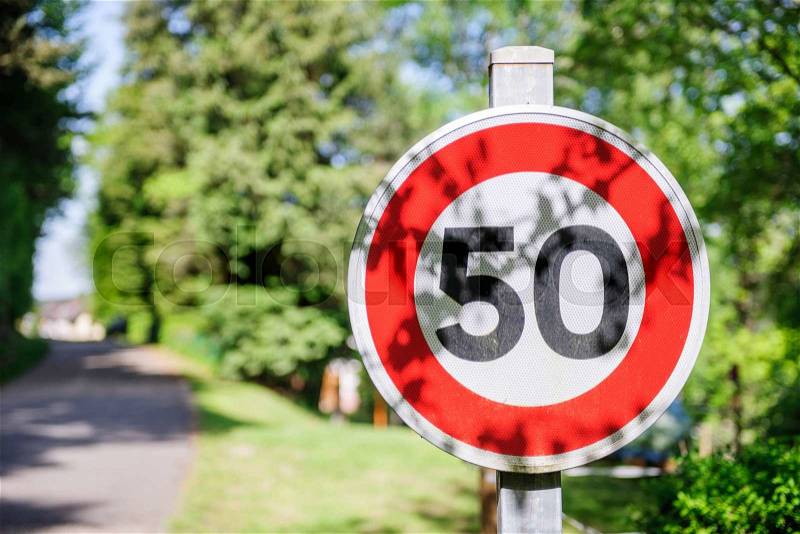 Warning sign or road sign for the maximum speed limit on a sunny summer day in green city. Useful file for your security brochure, stock photo