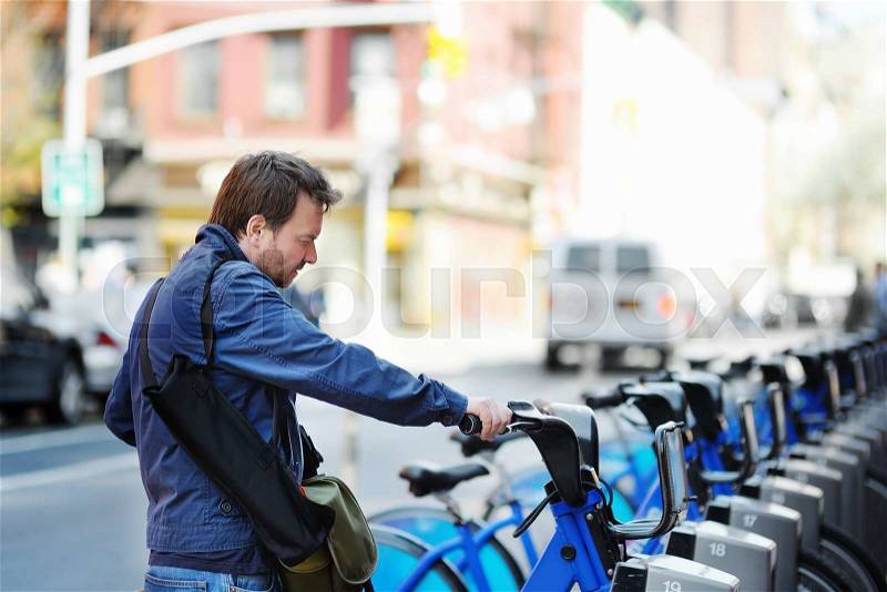 Middle age man taking a bicycle for rent in New York, USA, stock photo