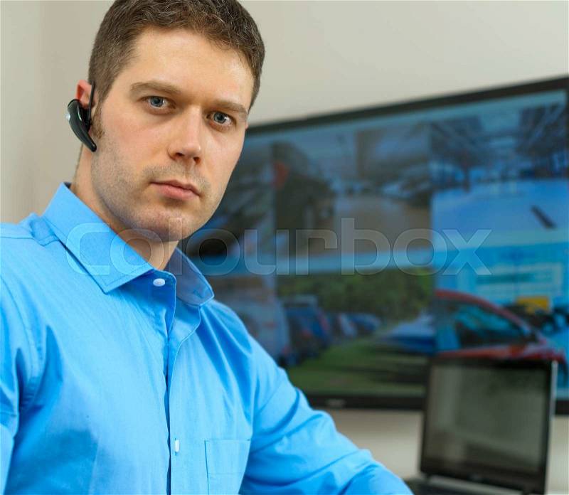 Security guard monitoring video in security room, stock photo