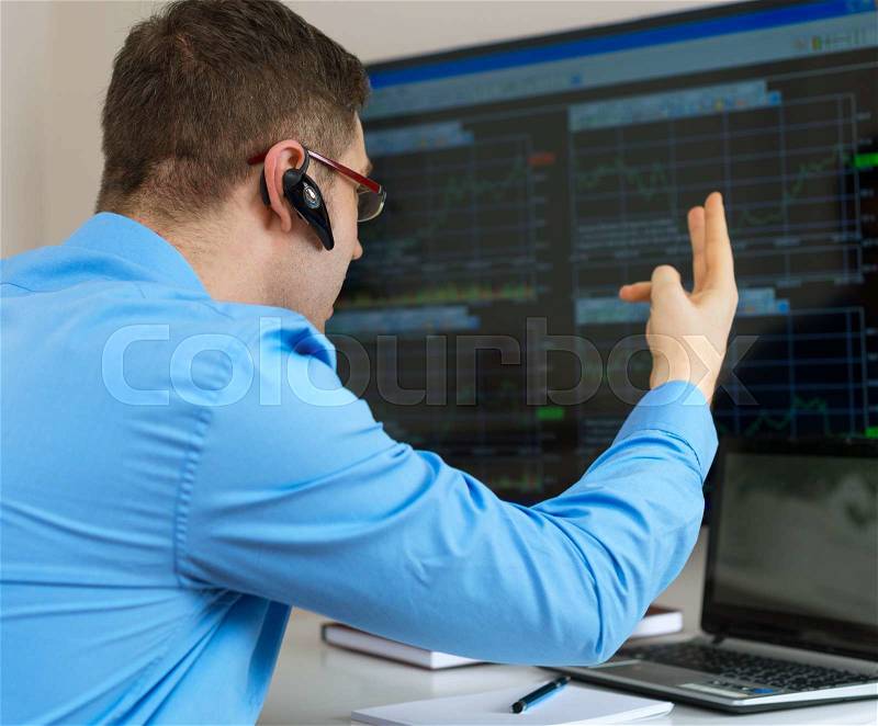 Angry stock trader in front of computer, stock photo