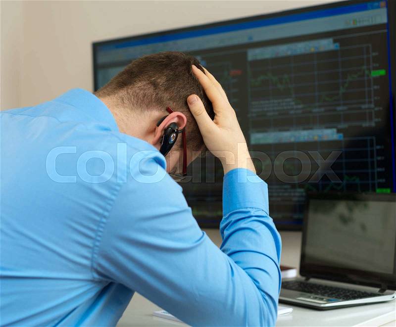 Upset stock trader in front of computer, stock photo