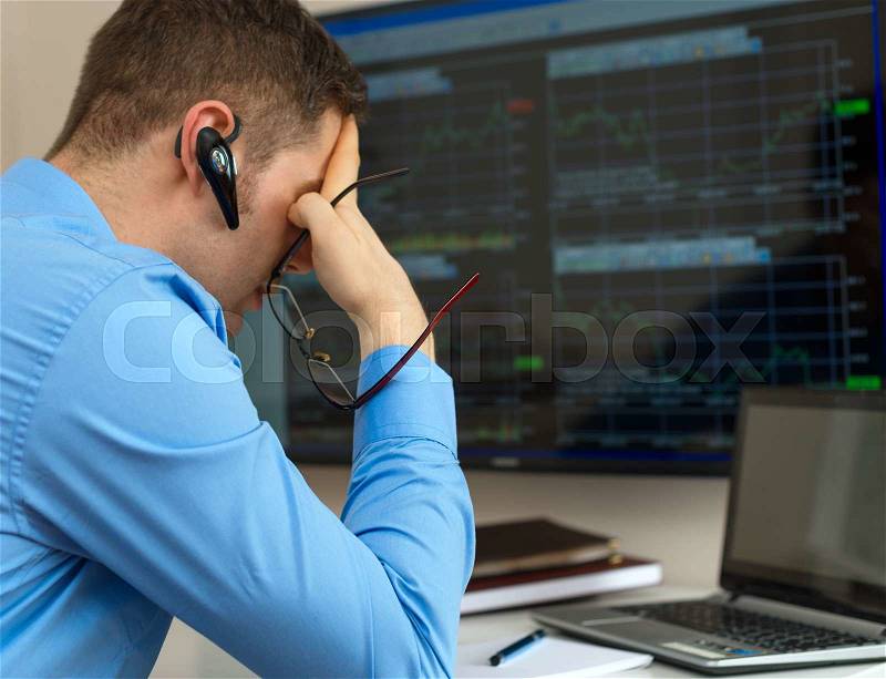 Upset stock trader in front of computer, stock photo