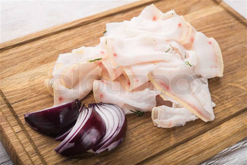 Fat tallow sliced with onion on wood table, stock photo