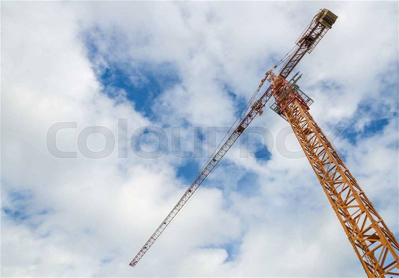 Crane and workers at construction site with blue sky background, stock photo