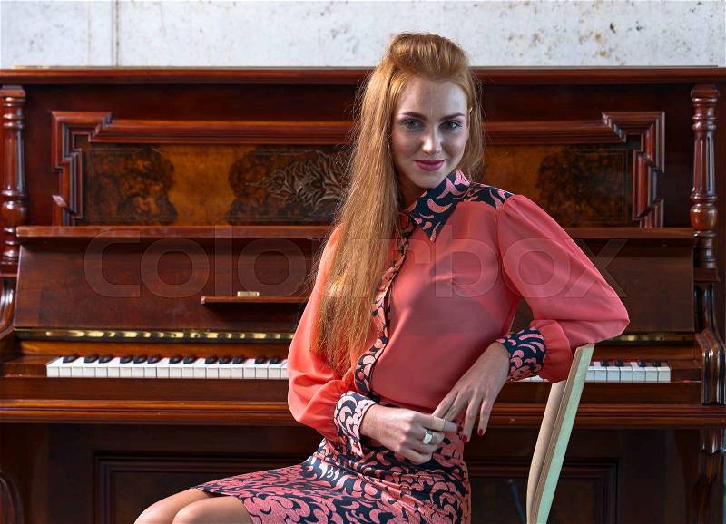 The young beautiful woman and old piano, stock photo