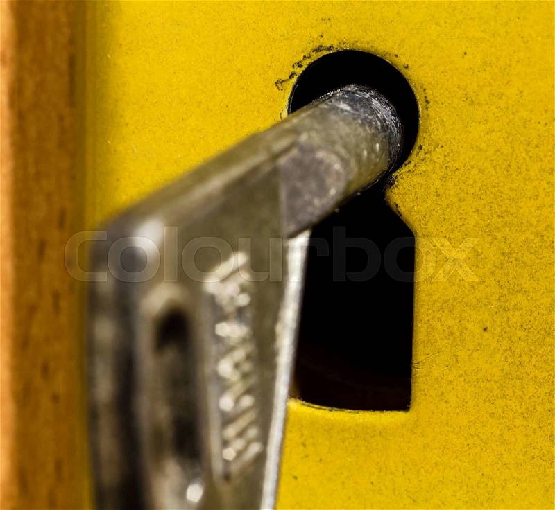 Old rusty key is sitting in the door eye, stock photo