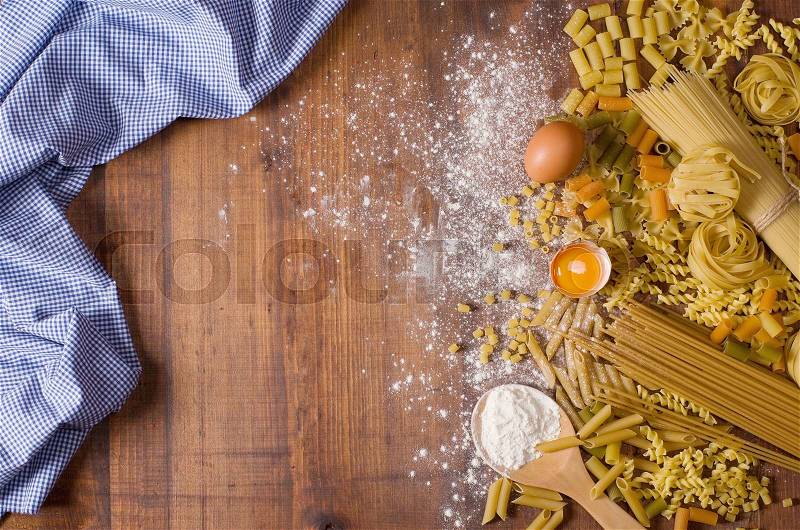 Raw pasta on wood background texture, stock photo