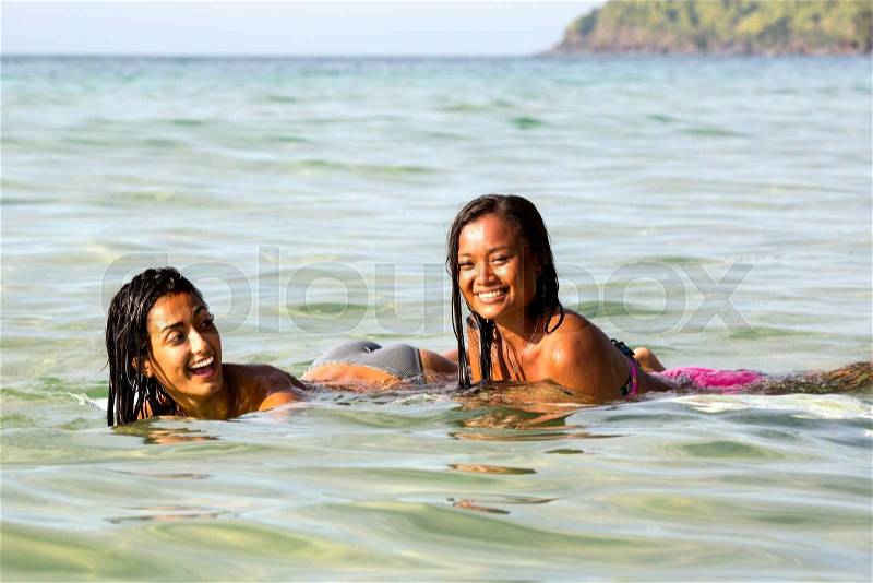 Two women on the board for surfing in the ocean swim, stock photo