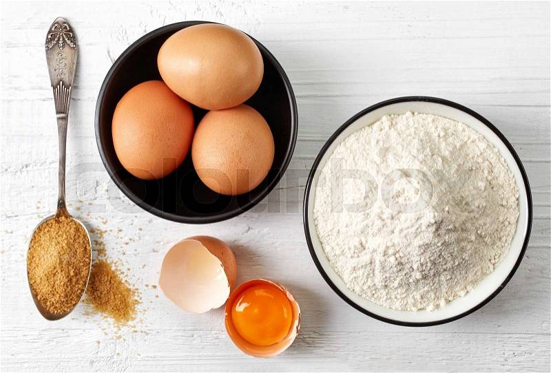 Baking, eggs, white flour and sugar on white wooden table, top view, stock photo