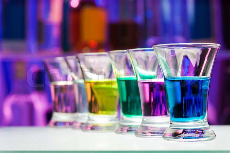 Color shoots perspective row in the dark bar bottles background, stock photo
