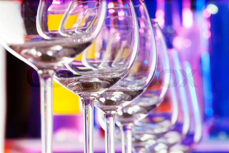 Transparent wine glass in a row composition in a bar with transparent glass , stock photo