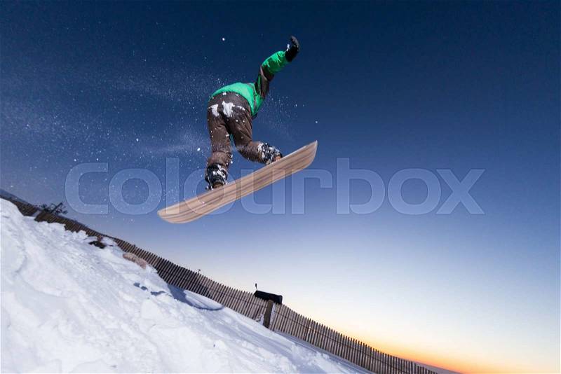 Young man snowboarding in the mountains, stock photo