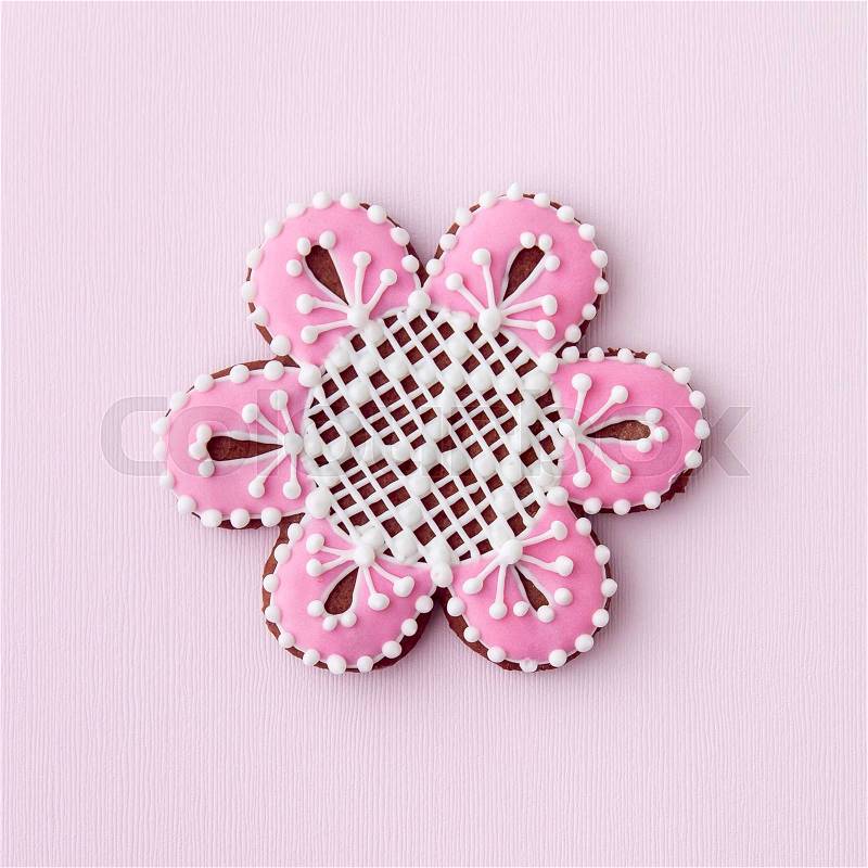 Home-baked and decorated flower shaped cookie on textured paper background, stock photo