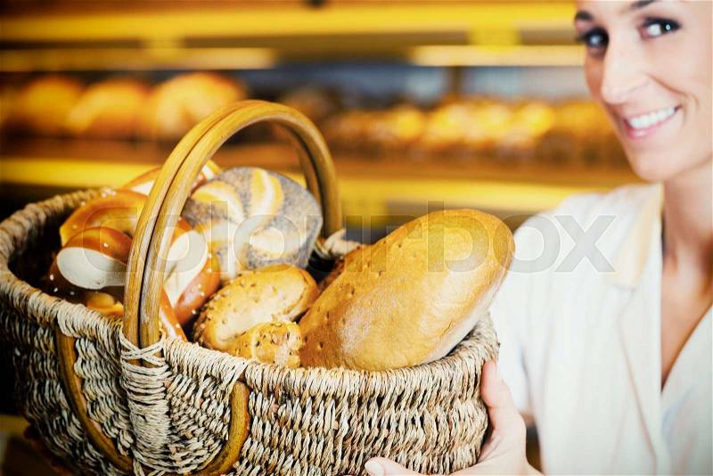 Baker woman in backer selling bread in basket, filtered image, stock photo