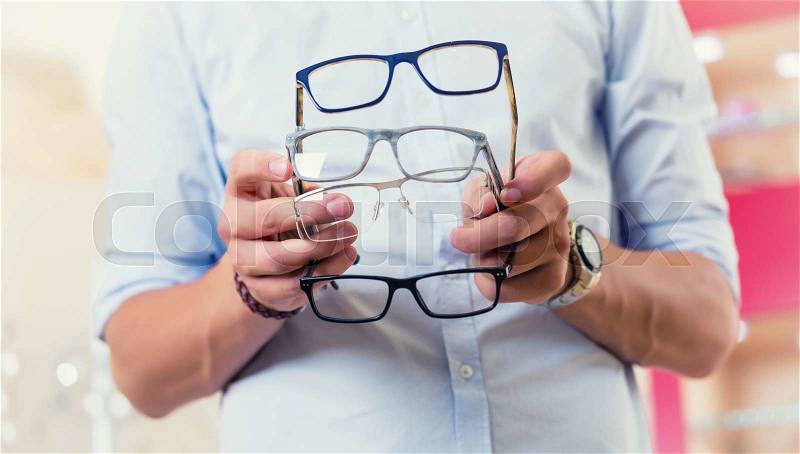 Man at optician or optometrist buying glasses, stock photo