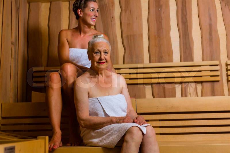 Senior and young woman in sauna sweating in heat, stock photo