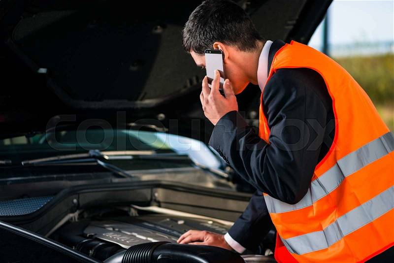 Man with car engine problems or breakdown calling repair service hotline, stock photo