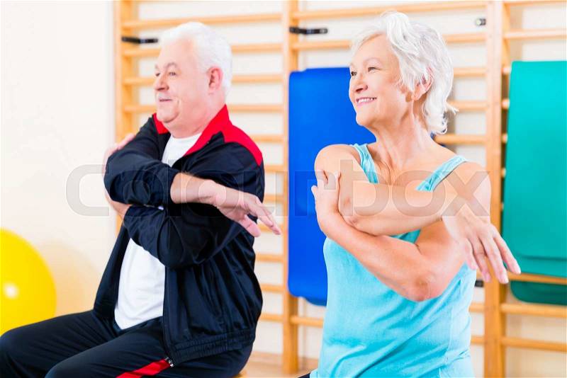 Senior people in fitness exercise doing gymnastic stretching, stock photo