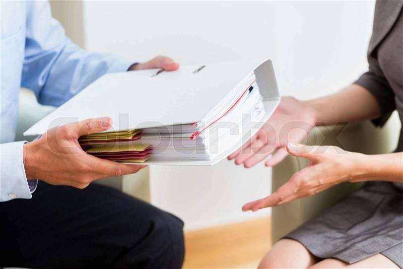 Financial consulting - customer handing over documents to consultant for further analysis, stock photo