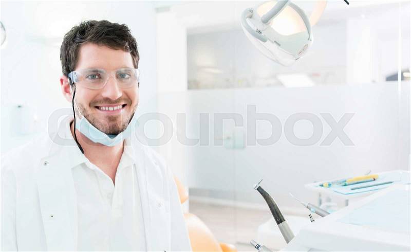 Dentist standing in dental surgery, stock photo