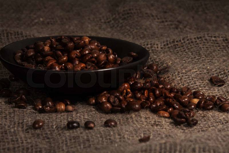 Coffee crops on the plate and the rusty linen cloth, stock photo
