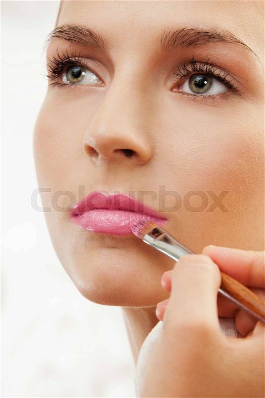 Grooming eyebrows with eyebrow brush - professional makeup artist working, stock photo