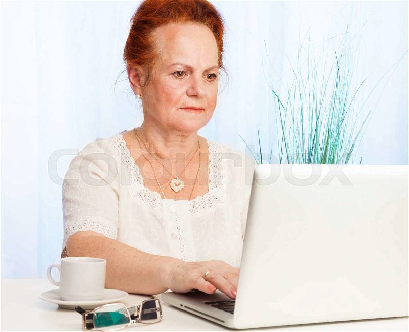 Nice old lady with white laptop, stock photo