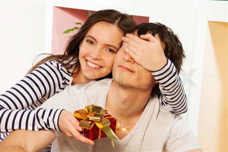 Present for him on the lovers Valentine\'s day, woman giving small present in red box to man, stock photo