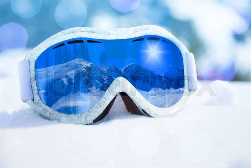 Close-up of ski and snowboard mask with mountain reflection in it, stock photo
