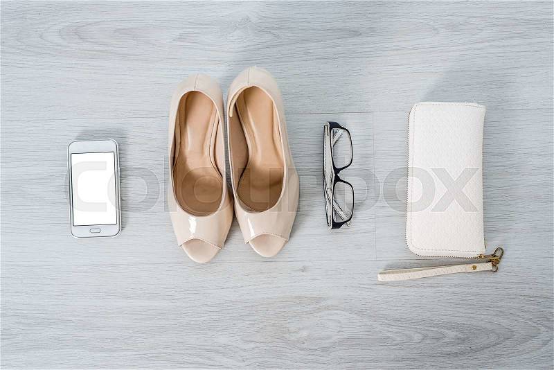 Shoes smart phone glasses and purse on gray background, stock photo