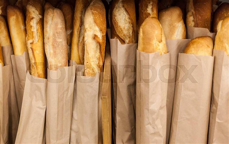 Lots of fresh crisp loaves of bread on shelves in supermarket, stock photo