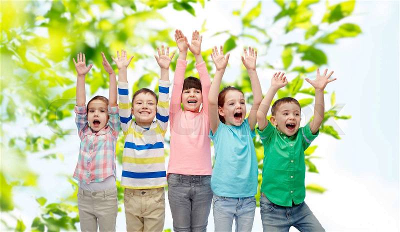 Childhood, summer, fashion, gesture and people concept - happy smiling friends raising fists and celebrating victory over green natural background, stock photo