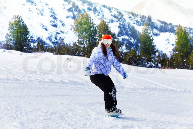 Girl in ski mask sliding with snowboard and balancing with hands, stock photo