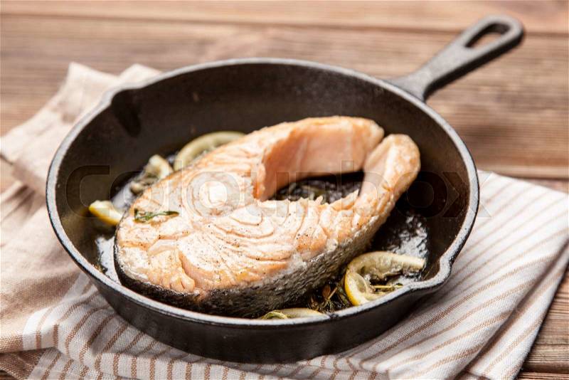 Salmon fried in a cast iron pan, stock photo