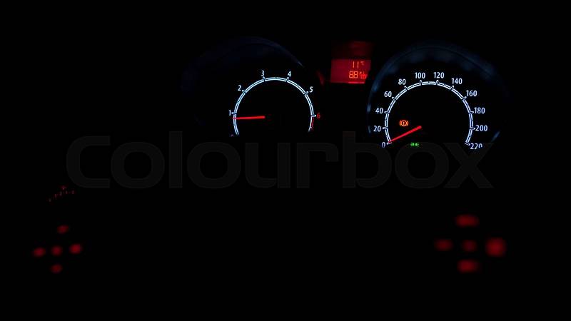 Car instrument panel illuminated at night, stock photo