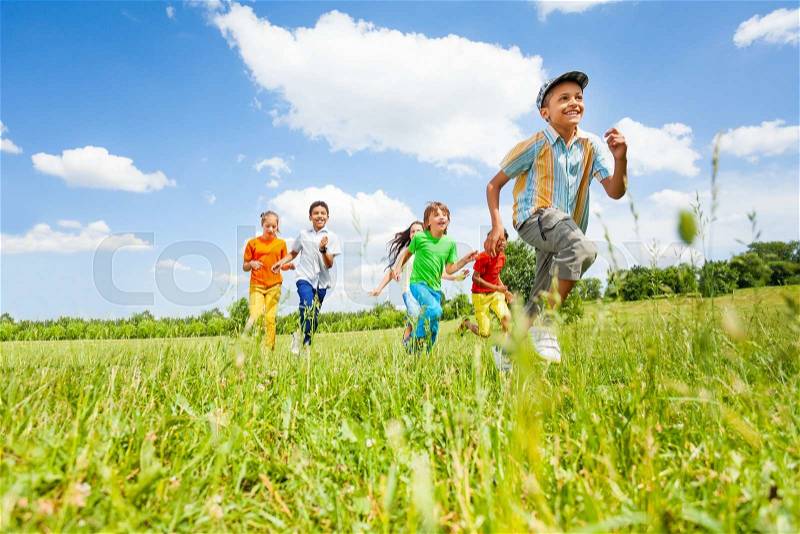 Happy kids playing and running in the field in summer, stock photo