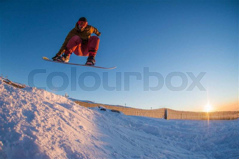 Young man snowboarding in the mountains, stock photo