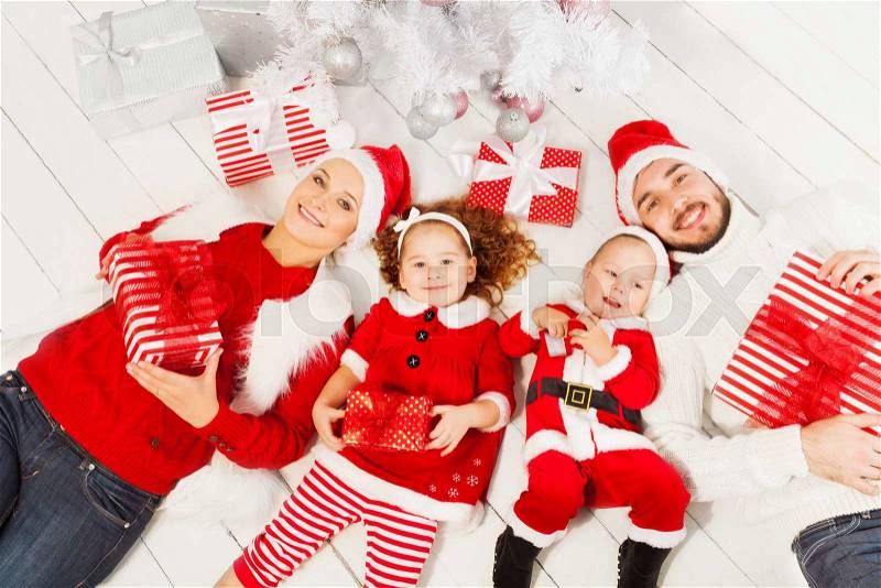 Family with little boy and girl lay under the Christmas tree with presents, view from above happy smiling , stock photo