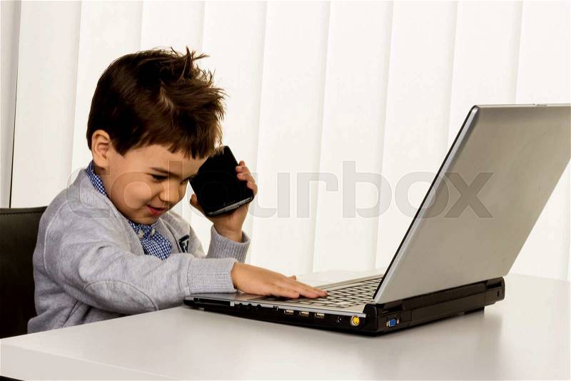 Little boy on a laptop, symbol of internet, e-commerce, consumer behavior, stock photo