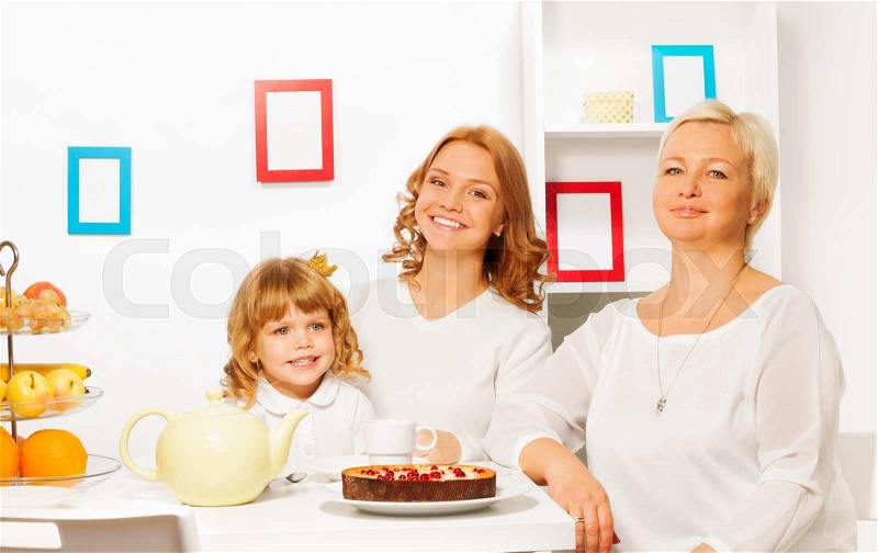 Happy family mother father and granddaughter eating cake by the table with smile, stock photo