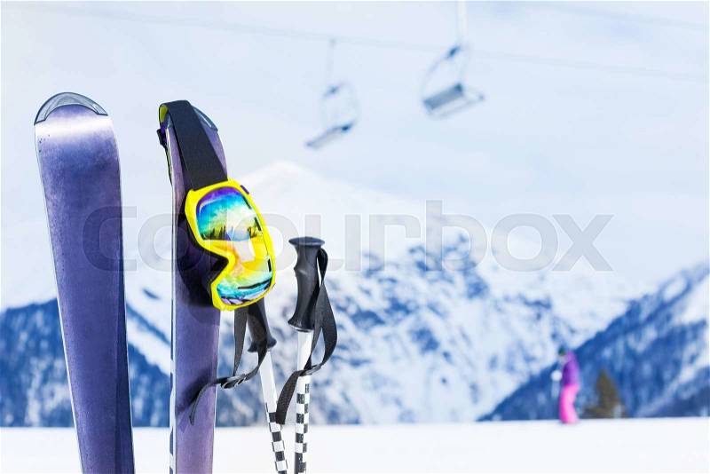 View of skies, ski mask and poles with mountain piste on background , stock photo