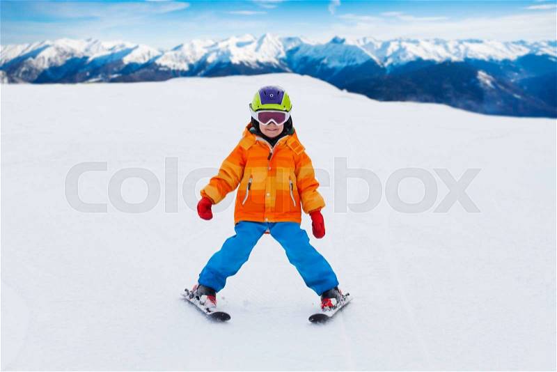 Boy wearing ski mask and helmet skiing on slope of Sochi ski resort Krasnaya polyana in Russia, stock photo