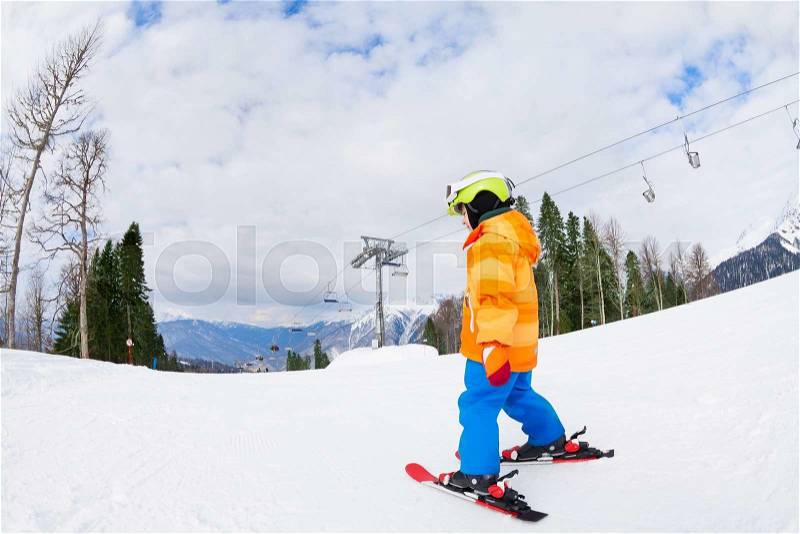 Boy from the back in ski mask and helmet skiing on Sochi ski resort Krasnaya polyana in Russia, stock photo
