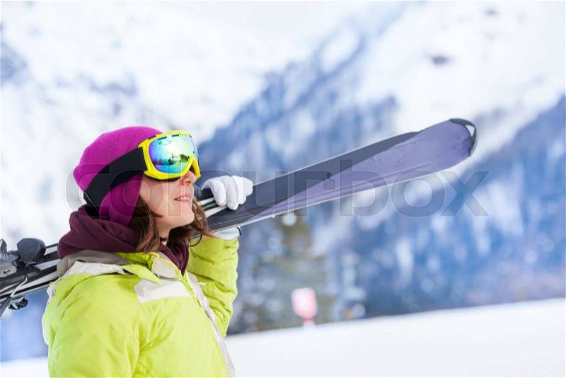 Girl in mask standing and holding ski during winter day on Krasnaya polyana ski resort and Caucasus mountains in Sochi, Russia, stock photo
