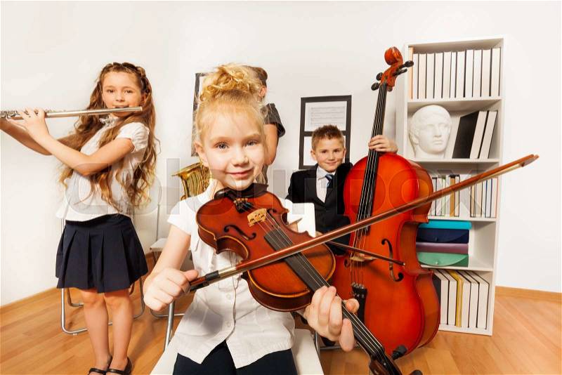 Performance of children who play musical instruments together in musical school, stock photo