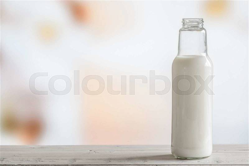 Bottle of milk standing on a wooden table, stock photo